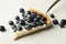 Spatula with blueberry pie slice on gray background