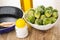 Spatula in frying pan, bottle of vegetable oil, frozen broccoli in bowl, salt on wooden table