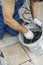 Spatula lies in a bucket with glue for tiles. worker spackles tile, selective focus