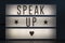 Speak up signage with stars and a heart on an illuminated whiteboard