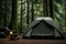 a speaker beside a tent in a forest campsite