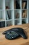 speakerphone on wooden table at office with blurred bookshelves