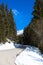 Specatcular winter road in austria with fir trees and blue sky
