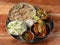 Special Chicken Thali from an indian cuisine, food platter consists of Chicken curry, lentils, jeera rice, roti and onions.,