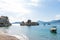 Special different rock in the adriatic sea in a small coast village in Budva. Small boats in the beach in turquoise blue water and