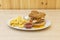Special hamburger with fried egg dripping yolk on lettuce and meat, two scoops with mayonnaise and ketchup sauce and a side of