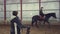 In special hangar, a young disabled man learns to ride a horse with close supervision teacher, hippotherapy. man has