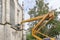 Special machine for lifting to a height. A worker makes restoration of an old building of the Evangelical Church at a high