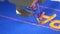 A special needle from a sewing machine embroider orange letters on blue fabric in a tailor shop or sewing workshop close
