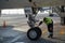 A specialist aircraft mechanic conducts preparatory work before takeoff of an air passenger ship at the parking lot