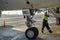 A specialist aircraft mechanic conducts preparatory work before takeoff of an air passenger ship at the parking lot