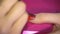 Specialist covers the nail of client by red varnish. Close up