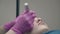 Specialist hands in pink sterile gloves with tattoo gun