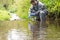 A specialist in a protective suit takes water into a flask from a river for analysis after the release of chemical agents from the