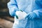 Specialist in a suit against viruses holds a mask in his hands