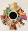 Specialty coffee concept. Black coffee in white cup on taster`s flavor wheel. Beans scattered around. Top view