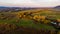 Spectacular aerial panorama of river flowing through fields at sunset.