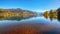 Spectacular autumn view of lake and trees in city park of Sell Am See