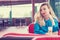 Spectacular blonde woman in the blue dress sitting at the cafe and drinking milk cocktail. Style photo with a vintage