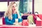 Spectacular blonde woman in the blue dress sitting at the cafe and drinking milk cocktail. Style photo with a vintage