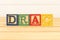 Spectacular colorful letters on wooden cubes on a wooden board with the word DRAG