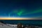 Spectacular dancing green strong northern lights over the famous round boulder beach near Uttakleiv on the Lofoten islands in