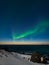 Spectacular dancing green strong northern lights over the famous round boulder beach near Uttakleiv on the Lofoten islands in
