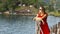 Spectacular girl in a red dress looks at water of tropical lagoon. Travel.