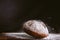 Spectacular image of fresh and rustic golden bread falling on wood kitchen table with flour explosion against black background.