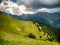 Spectacular mountain landscape with clouds hovering above mountain slopes filled with bushes of rhododendron kotschyi in fagaras m