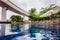 Spectacular pool surrounded with desk chairs and green tropical trees