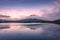 Spectacular reflection of the mountains on a lake with mist under the midnight sun, fairy tale atmosphere in the Vesteralen