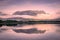 Spectacular reflection of the mountains on a lake with mist under the midnight sun, fairy tale atmosphere in the Vesteralen