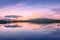 Spectacular reflection of the mountains on a lake with mist under the midnight sun, fairy tale atmosphere in the Vesteralen