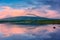 Spectacular reflection of the mountains on a lake with mist under the midnight sun, fairy tale atmosphere in the Vesteralen