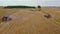 Spectacular straight down zoom out rotating aerial view of two combine harvesters harvesting wheat