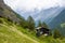 Spectacular summer alpine landscape, mountain swiss wooden chalet with high mountains in background, Zermatt