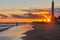 Spectacular sunset at the beach of Maspalomas in National park and sand dunes. Fishermen and famous lighthouse in southern peak of