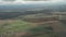 Spectacular view from plane on earth with tiny houses, fields, windmills, woods.