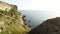 Spectacular view of steep dliffs at the ocean, Ireland. Shot. Green slope near calm water and the endless horizon on