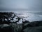 Spectacular waves breaking over huge icebergs on diamond beach with tourists