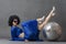 Spectacular Woman in a sparkly flared suit and afro wig poses with a disco ball