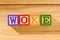 Spectacular wooden cubes with the word WOKE on a wooden surface