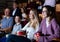 Spectators eating popcorn and watching movie at the cinema