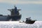 Speed boat passing in full speed in front of a trans-ocean container ship tanker in Vancouver English Bay