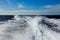 A speed boat wake speedy prop wash foam in Andaman sea with blue sky background in summer, Satun, Thailand