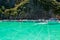 Speed boats docking on anchors near cliff in Maya Bay