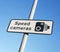 Speed camera warning sign against blue sky