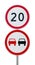 Speed limit sign 20 and no overtaking road sign on a metal pole.