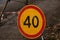 Speed limit sign due to road work indicating a maximum speed of 40 kilometers per hour. Round traffic sign on the ground